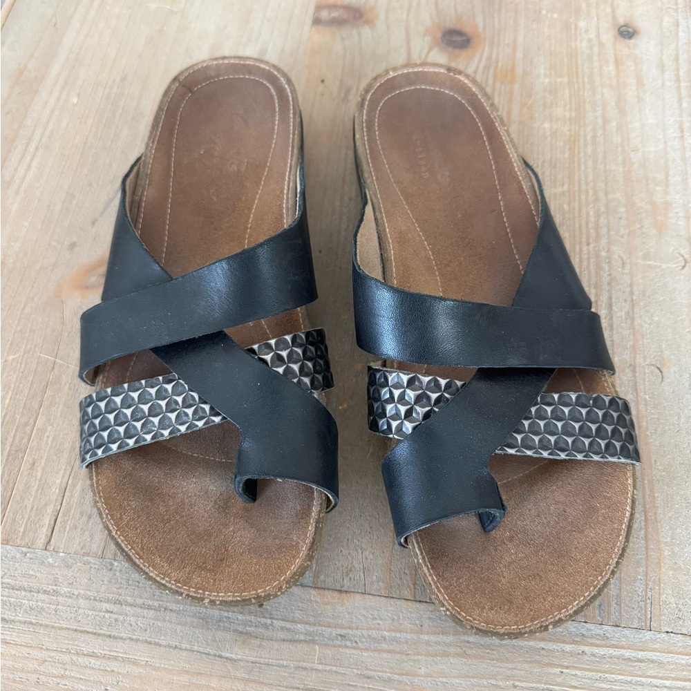 Clark's black and metallic leather cross-strap sandals. Leather footbed.